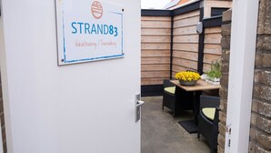 A sign for STRAND83 with a logo and text indicating it is a vacation rental.