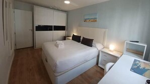 Una habitación de hotel con cama, mesitas de noche, escritorio y armario.