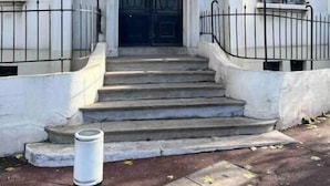 A building with a grand entrance, featuring a set of steps leading to a double door with decorative ironwork. - Charmant Appartement Joinvillais (Joinville-le-Pont)
