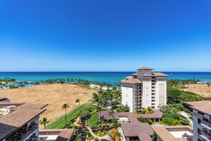 A resort with a view of the ocean, a pool area, and a building with multiple floors.