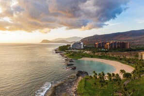 Ein Küstenresort mit Strandhäusern, felsiger Küstenlinie und Bergblick.