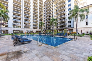 Un hôtel doté d’une grande piscine, de nombreux balcons et d’une façade en pierre.