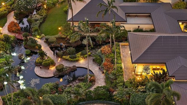 A resort with a swimming pool, landscaped gardens, and a well-lit outdoor area.