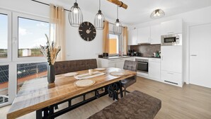 Una cocina moderna con armarios blancos, un microondas y una estufa.