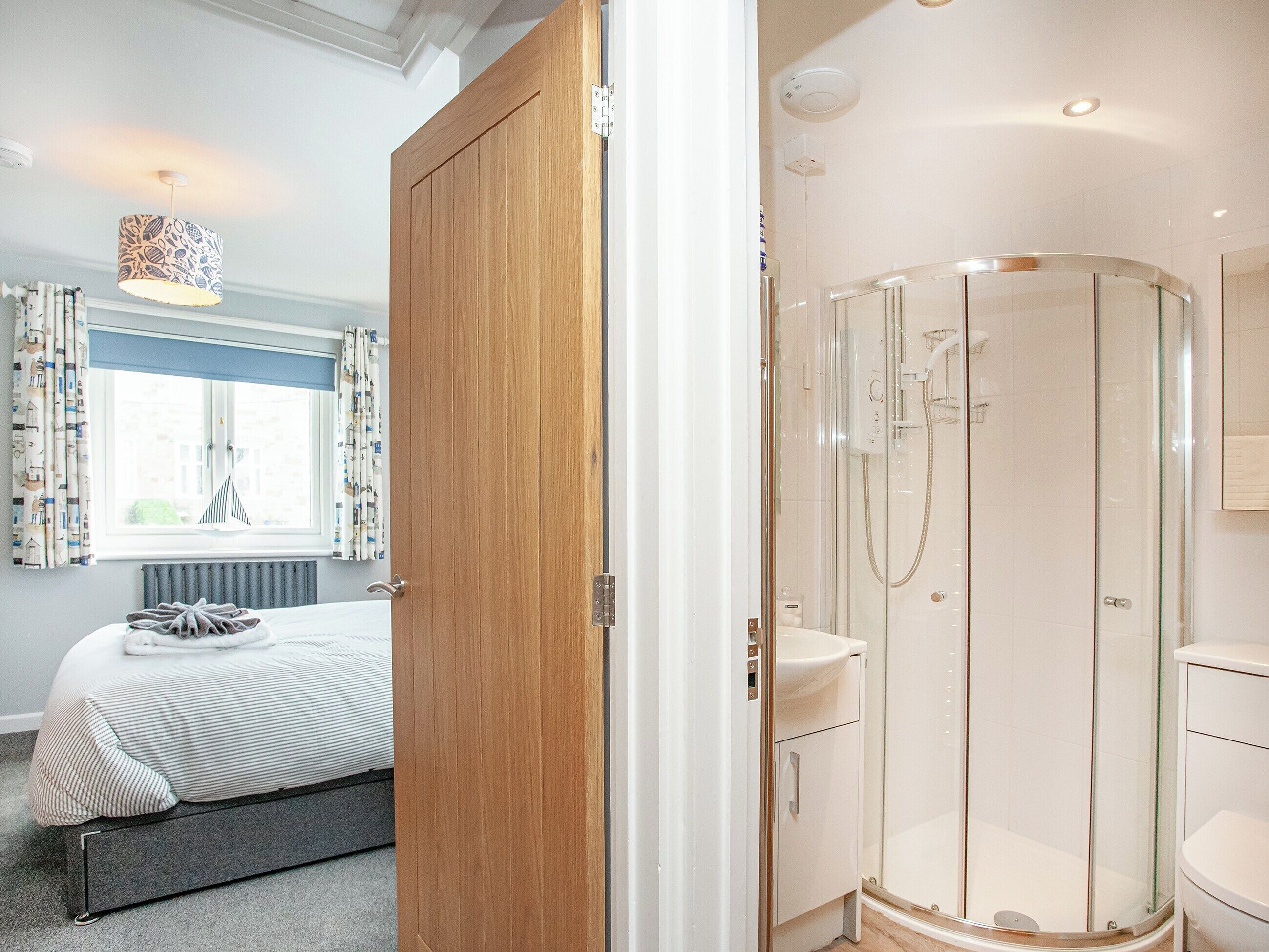 Une chambre à coucher avec un lit, une table de chevet et une fenêtre avec des rideaux.