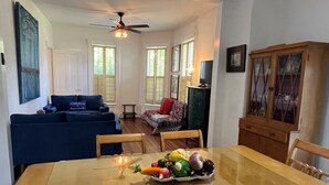Un comedor con una mesa de madera, un sofá azul y un armario.