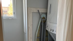 A laundry room with a washing machine, dryer, and a window.