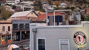 A residential area with houses on a hillside and a building with a sign for Old Biscbee Brewing Company. - Deluxe Room at The Block (Bisbee)