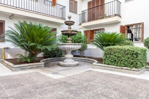Stroll through the serene courtyard, surrounded by lush greenery and a central fountain.