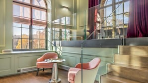 A modern interior with a staircase, large windows, and two chairs. - Le Loft 150 m² vue rivière (Lyon)