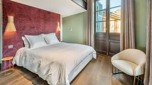 A modern bedroom with a large bed, a chair, and a window with curtains. - Le Loft 150 m² vue rivière (Lyon)