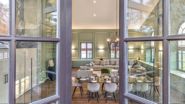 A modern interior with a dining area, sofas, and a staircase. - Le Loft 150 m² vue rivière (Lyon)
