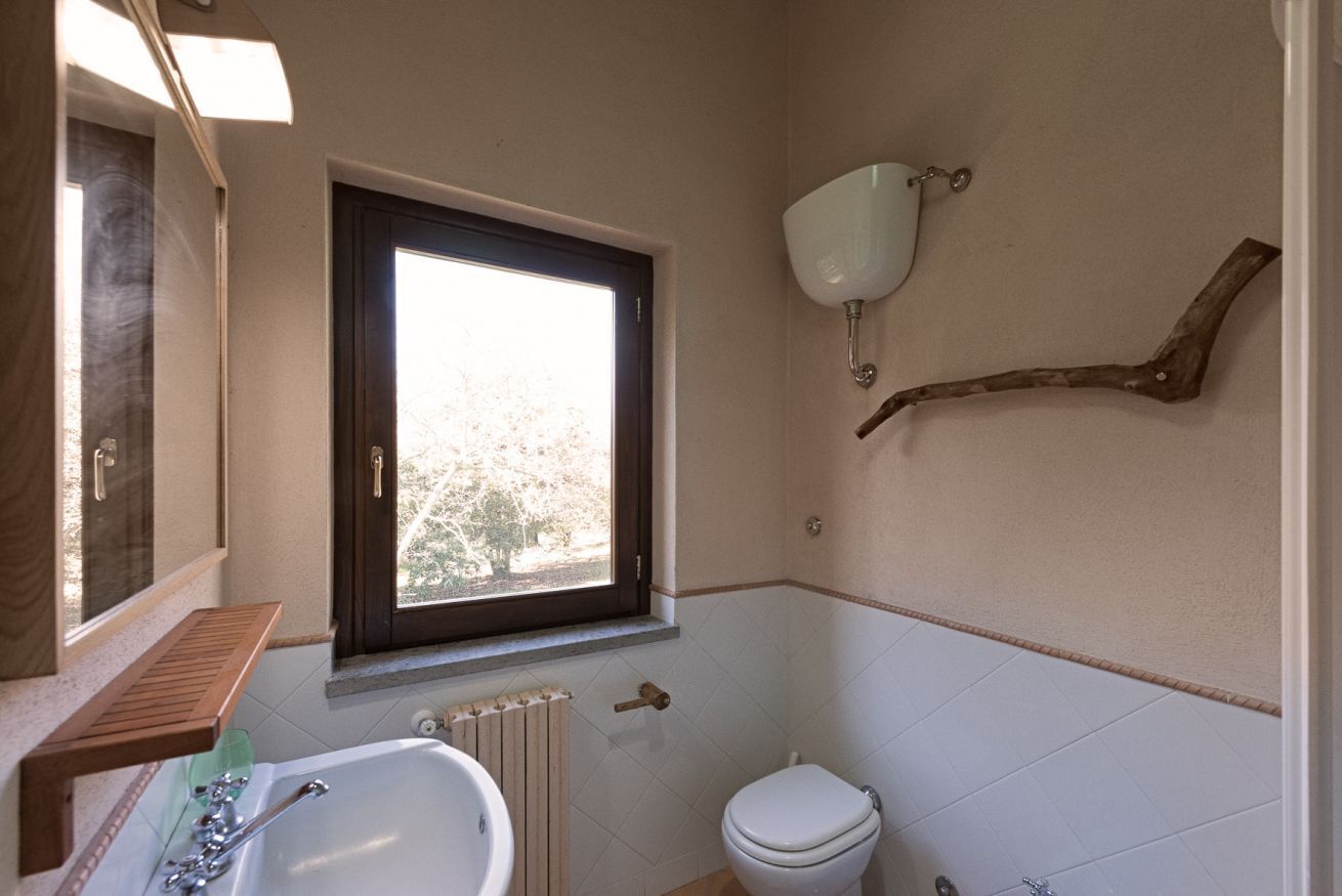 A bathroom with a bathtub, toilet, and a window.