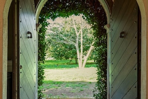 An arched doorway leading to a grassy area with trees. - Casale Pomodoro - Pool in an Ancient Woodland (Manziana)