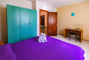 Una habitación con cama, escritorio y armario.