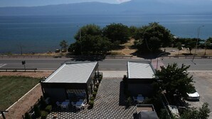 A building with a tiled patio area, outdoor seating, and a view of the sea. - Pashkaj Hotel (Udënisht)