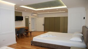 A bedroom with a bed, a desk, and a TV. - Pashkaj Hotel (Udënisht)