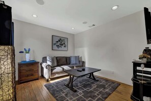 Un salon moderne avec un canapé, une table basse et des œuvres d’art accrochées au mur.