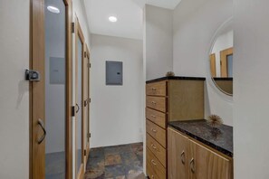 Ein Flur mit einer Holztür, einem Spiegel und einem Schrank mit Schubladen.
