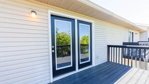 A house with a front porch, a sliding glass door, and a small deck. - Memorial Field Lodge - 4 Bd Townhome by IU Sports (Bloomington)