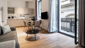 Eine moderne Wohnung mit Essbereich, Küche und einem Balkon mit schmiedeeisernen Geländern.