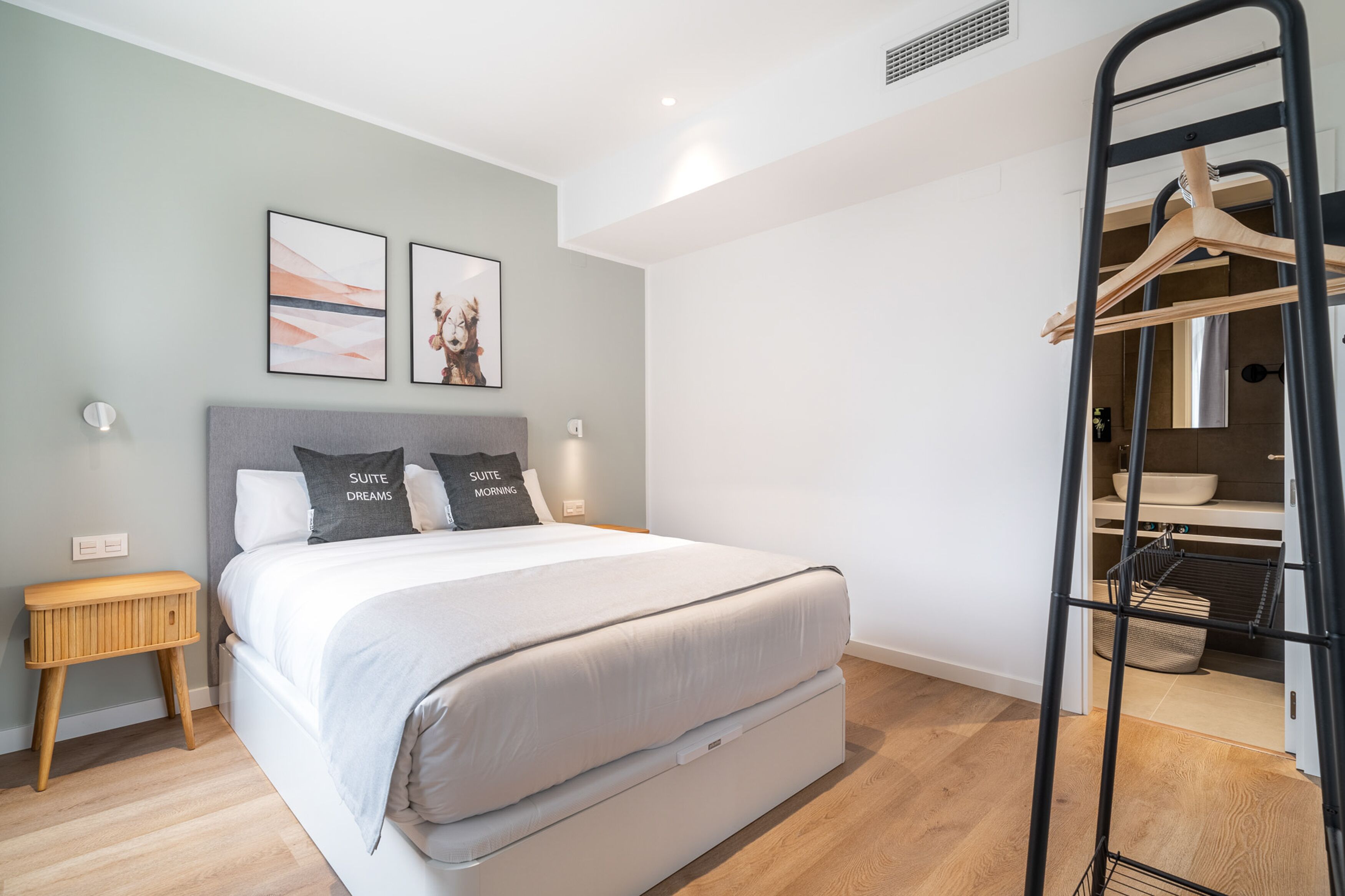 Une chambre à coucher moderne avec un lit, des tables de chevet et une armoire.