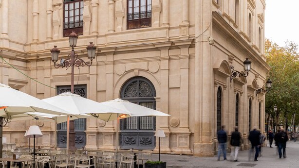 Ein historisches Gebäude mit Rundbogenfenstern und einem Kopfsteinpflasterhof.