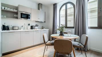 Enjoy a compact kitchen with essential appliances and ample storage, plus a dining area with a round table and city views.