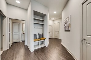 A hallway with a built-in bench, white walls, and a wooden floor. - LC058-3 - Home|Yard|8mi to Fair Park|Sleeps 6 (Irving)