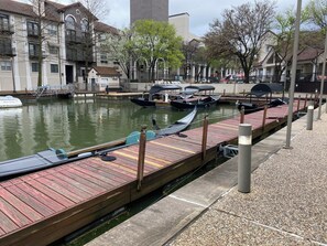 A canal with boats docked on wooden piers, surrounded by buildings and trees. - LC058-3 - Home|Yard|8mi to Fair Park|Sleeps 6 (Irving)