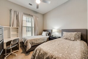 A hotel room with two beds, a desk, a chair, a nightstand, and a ceiling fan. - LC058-3 - Home|Yard|8mi to Fair Park|Sleeps 6 (Irving)