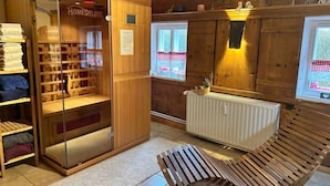 Un intérieur en bois avec un meuble de rangement à façade vitrée portant l’inscription « HomeDeluxe », un radiateur et un banc.