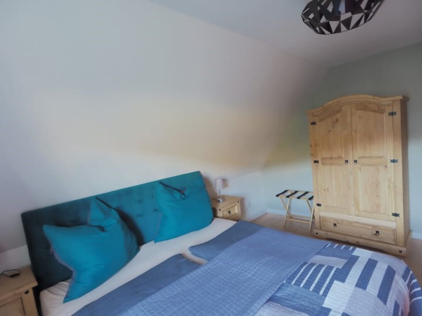 Ein Schlafzimmer mit einem Bett, einem Holzschrank und einem Nachttisch.