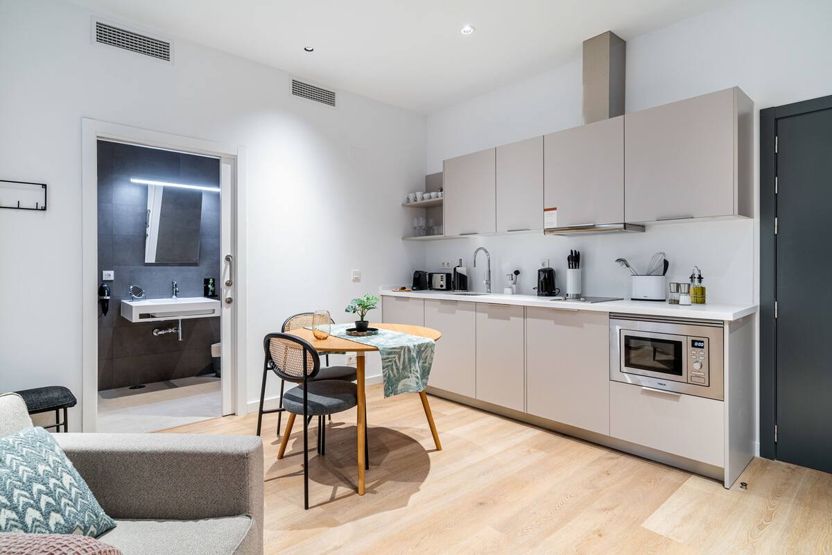 A modern kitchen with a dining area, built-in appliances, and a small dining table.