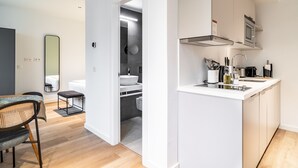 A modern kitchen with white cabinetry, a built-in microwave, and a sink. - Limehome Sevilla Ronda de Capuchinos (Seville)