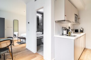 A modern kitchen with white cabinetry, a built-in microwave, and a sink.
