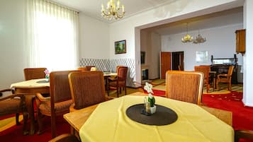 A dining area with a round table, chairs, and a chandelier.