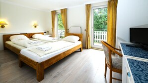 A double bed with white linens, a wooden headboard, and two bedside lamps. - Hotel Haus Am Walde (Bad Fallingbostel)