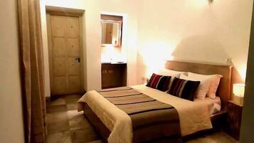 Un dormitorio con cama, mesita de noche, espejo y aire acondicionado.