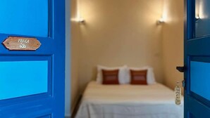 Una habitación con una cama, una puerta azul y un letrero que dice 'FELLA'.