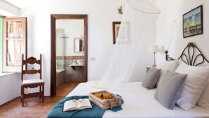 A bedroom with a bed, bedside table, chair, and a window. - Villa La Fenice by Wonderful Italy (Castellammare del Golfo)