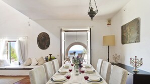 A dining room with a table set for six, a view to the outside, and a chandelier. - Villa La Fenice by Wonderful Italy (Castellammare del Golfo)