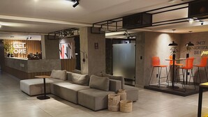 Ein modernes Wohnzimmer mit einer Eckcouch, einer Bar und orangefarbenen Stühlen.