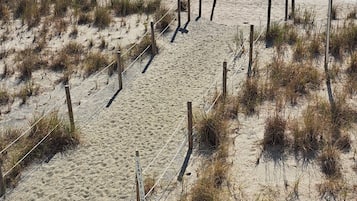 En sandstrand med et hegn og et skilt, der står "TAY OFF DUNES".