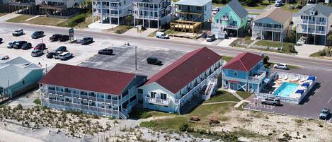 A coastal hotel with multiple stories, balconies, and a swimming pool.
