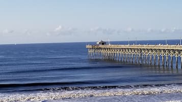 A pier extending into the ocean with a clear sky above.