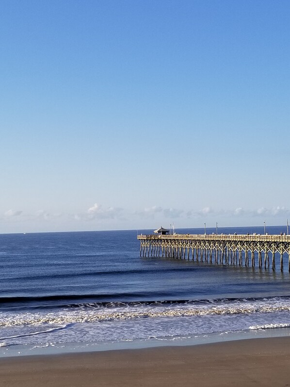 A pier extending into the ocean with a clear sky above. - Ocean Crest Motel (Oak Island)