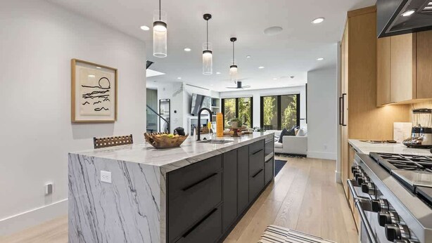 A modern kitchen with a marble island, black cabinetry, and stainless steel appliances. - Abode at Hollow Mountain, private hot tub, sound system, garden (Park City)