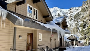A wooden cabin with a snow-covered roof and icicles hanging from the eaves. - Cozy Ski-in Ski-out Snowbird Townhouse (Alta)