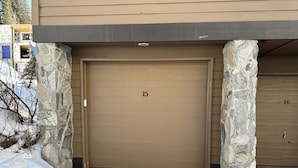 A brown garage door with the number 15, flanked by stone pillars, in a snowy setting. - Cozy Ski-in Ski-out Snowbird Townhouse (Alta)